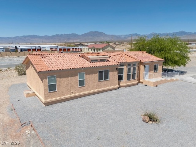2530 Commercial Dr, Pahrump, NV 89048 - back of house featuring stucco siding, a mountain view, and a tiled roof