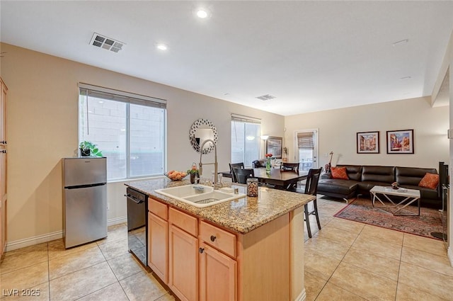 9715 Aleutian St, Las Vegas, NV 89178 - kitchen with freestanding refrigerator, black dishwasher, open floor plan, light brown cabinetry, and an island with sink