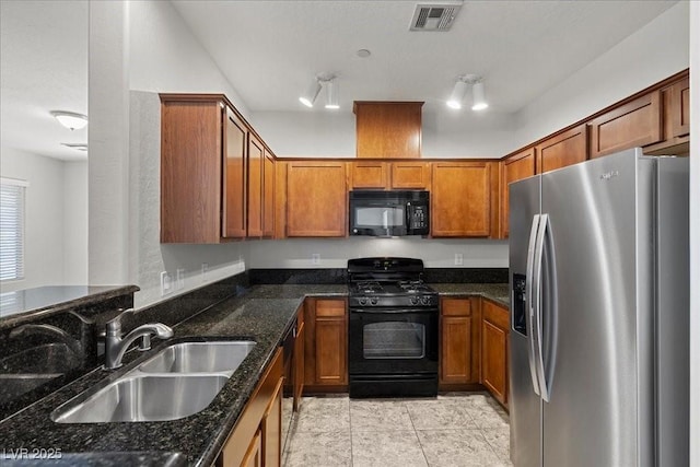 6868 Sky Pointe Dr Unit 2035, Las Vegas, NV 89131 - kitchen with black appliances, brown cabinetry, dark stone countertops, and light tile patterned floors