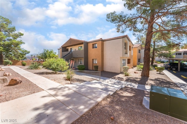 3151 Soaring Gulls Dr Unit 1021, Las Vegas, NV 89128 - view of front facade featuring stucco siding, a tiled roof, a balcony, and a residential view