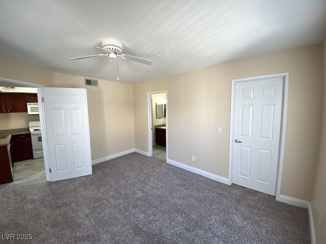 6800 E Lake Mead Blvd Unit 2024, Las Vegas, NV 89156 - unfurnished bedroom with light carpet, ensuite bath, and a ceiling fan