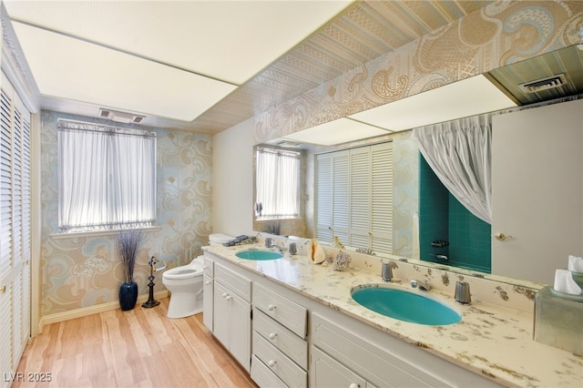 226 Dalmatian Ln, Las Vegas, NV 89107 - bathroom featuring wallpapered walls, wood finished floors, and double vanity