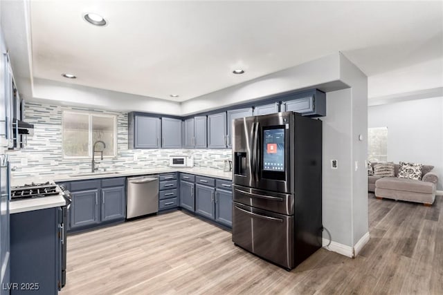 3825 Manhattan Bridge Pl, North Las Vegas, NV 89032 - kitchen with stainless steel appliances, light countertops, light wood-style floors, tasteful backsplash, and recessed lighting