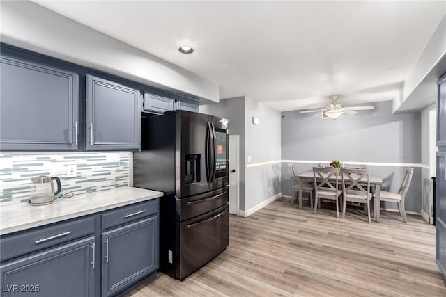 3825 Manhattan Bridge Pl, North Las Vegas, NV 89032 - kitchen featuring fridge with ice dispenser, ceiling fan, backsplash, light countertops, and light wood-type flooring