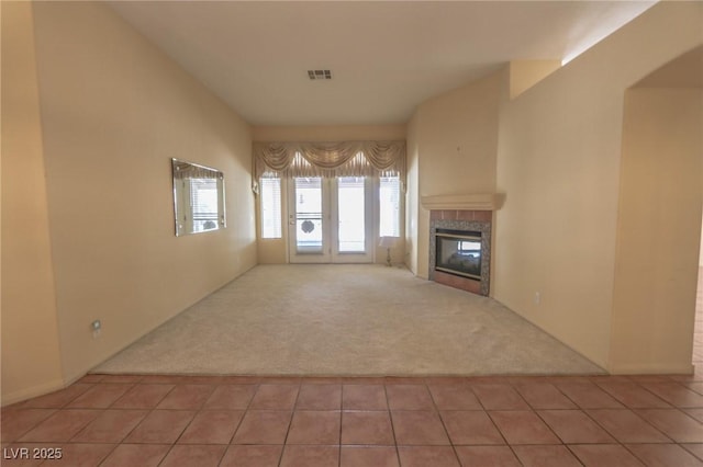 1174 Monogram Way, Las Vegas, NV 89123 - unfurnished living room featuring carpet flooring, a tiled fireplace, and tile patterned flooring