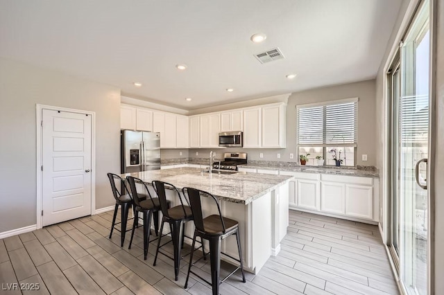 5606 Verde Valley Ct, North Las Vegas, NV 89081 - kitchen with appliances with stainless steel finishes, wood tiled floors, white cabinetry, and recessed lighting