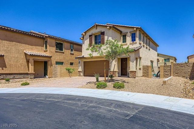 5606 Verde Valley Ct, North Las Vegas, NV 89081 - mediterranean / spanish home featuring an attached garage, driveway, stucco siding, stone siding, and a tiled roof