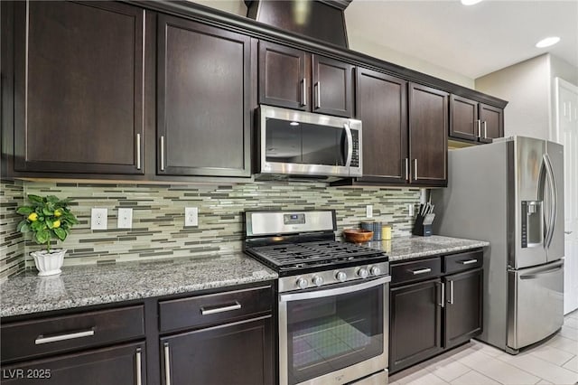 1922 Via Delle Arti, Henderson, NV 89044 - kitchen with appliances with stainless steel finishes, dark brown cabinetry, light stone countertops, backsplash, and recessed lighting