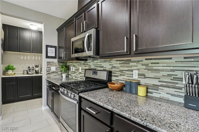1922 Via Delle Arti, Henderson, NV 89044 - kitchen with stainless steel appliances, light stone counters, tasteful backsplash, and dark brown cabinets