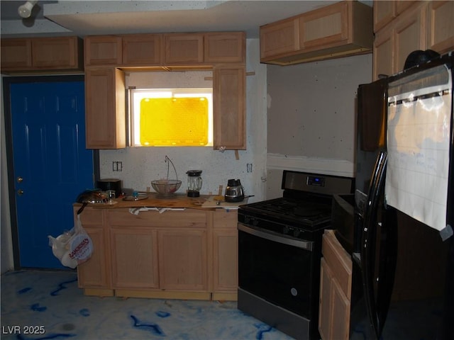 5068 Killarney St, Las Vegas, NV 89122 - kitchen with black fridge, range with gas cooktop, light brown cabinetry, and light countertops