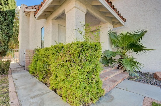 8809 Beach Front Dr, Las Vegas, NV 89117 - view of property exterior featuring stucco siding, a tile roof, and a gate
