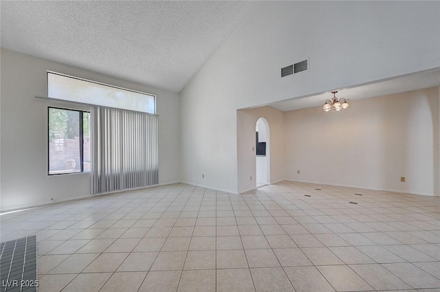 8809 Beach Front Dr, Las Vegas, NV 89117 - spare room featuring a chandelier, a textured ceiling, high vaulted ceiling, arched walkways, and light tile patterned floors