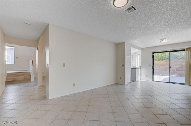 8809 Beach Front Dr, Las Vegas, NV 89117 - empty room with a textured ceiling, light tile patterned floors, stairs, and a smoke detector