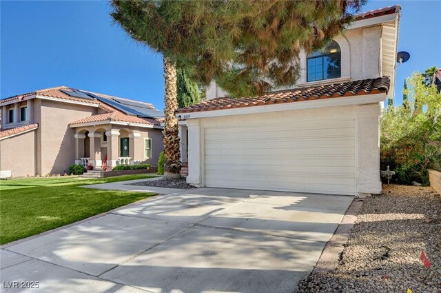8809 Beach Front Dr, Las Vegas, NV 89117 - mediterranean / spanish-style house featuring a tile roof, stucco siding, concrete driveway, and a front yard