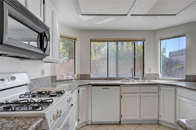 8809 Beach Front Dr, Las Vegas, NV 89117 - kitchen with white appliances, white cabinets, and light tile patterned floors