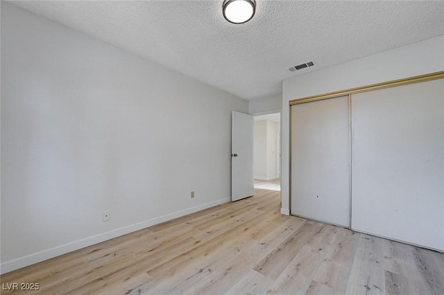 8809 Beach Front Dr, Las Vegas, NV 89117 - unfurnished bedroom with light wood-type flooring, a textured ceiling, and a closet