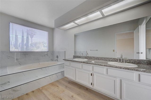 8809 Beach Front Dr, Las Vegas, NV 89117 - bathroom featuring double vanity, a bath, and wood finished floors
