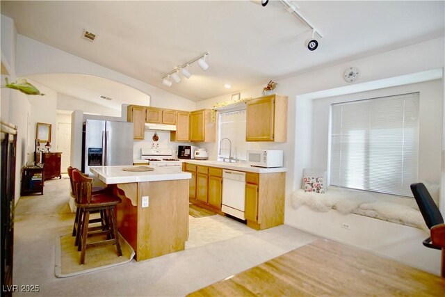 6131 Pumpkin Patch Ave, Las Vegas, NV 89142 - kitchen with rail lighting, white appliances, lofted ceiling, a center island, and light countertops