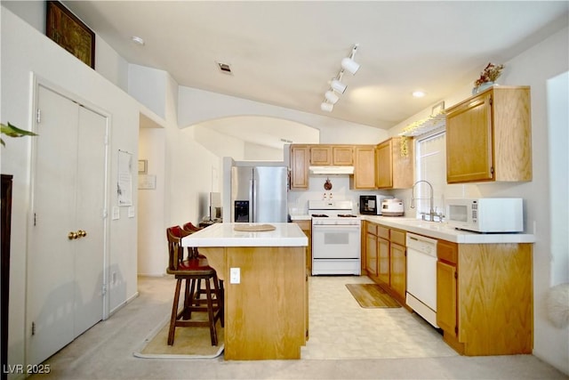 6131 Pumpkin Patch Ave, Las Vegas, NV 89142 - kitchen featuring white appliances, lofted ceiling, a kitchen island, light countertops, and a breakfast bar area