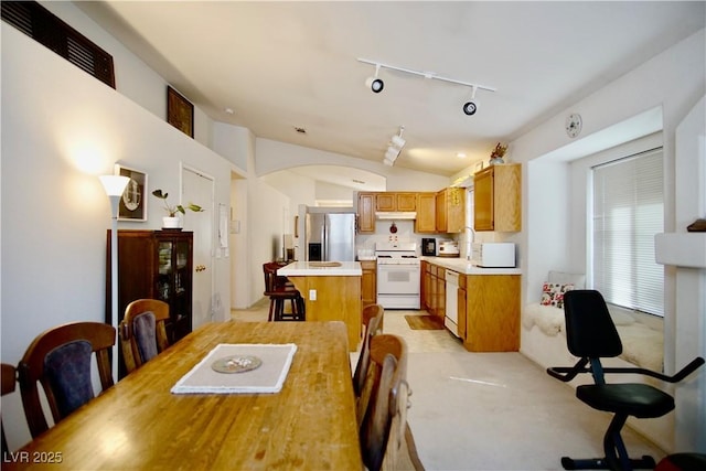 6131 Pumpkin Patch Ave, Las Vegas, NV 89142 - dining room with lofted ceiling, rail lighting, light carpet, and arched walkways