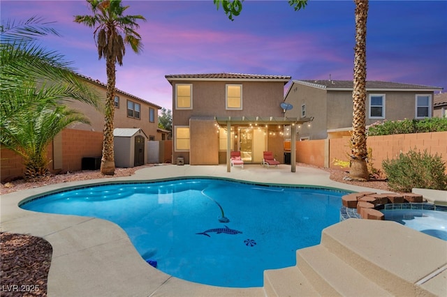 11649 Royal Derwent Dr, Las Vegas, NV 89138 - pool at dusk featuring a storage shed, a fenced backyard, a patio, and a pool with connected hot tub