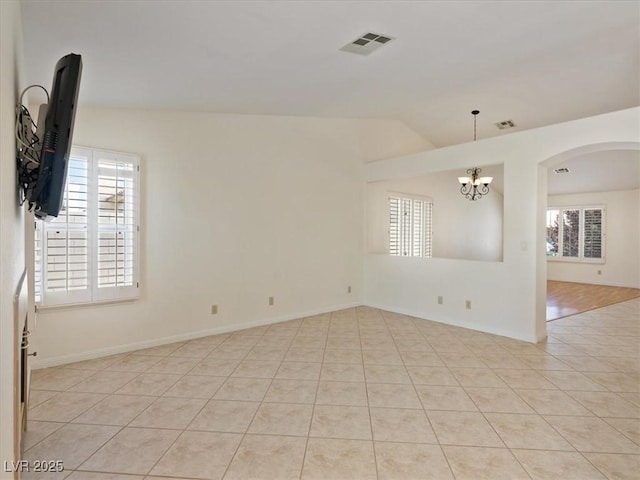 4323 Pageantry Falls Dr, North Las Vegas, NV 89031 - empty room with healthy amount of natural light, a chandelier, light tile patterned flooring, arched walkways, and lofted ceiling