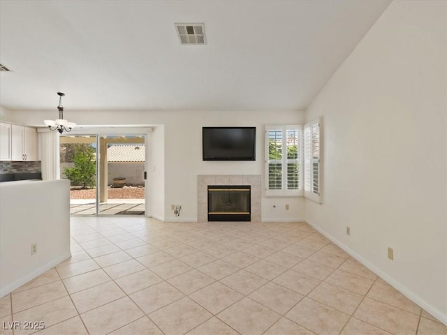 4323 Pageantry Falls Dr, North Las Vegas, NV 89031 - unfurnished living room with a chandelier, a tiled fireplace, and light tile patterned flooring