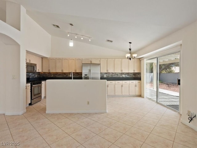 4323 Pageantry Falls Dr, North Las Vegas, NV 89031 - kitchen featuring appliances with stainless steel finishes, vaulted ceiling, backsplash, dark countertops, and light tile patterned floors