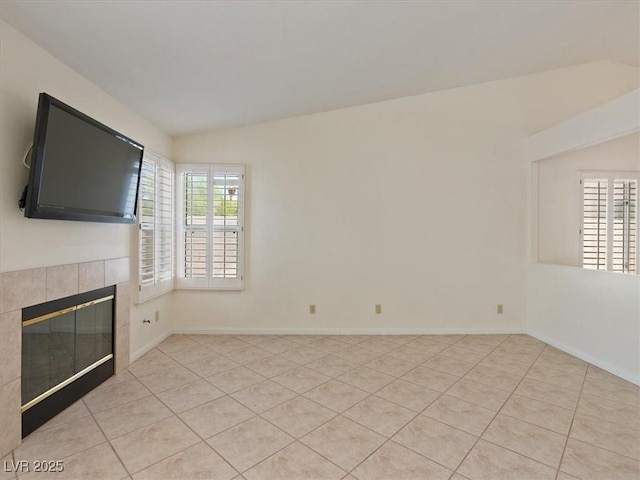 4323 Pageantry Falls Dr, North Las Vegas, NV 89031 - unfurnished living room featuring a tile fireplace, light tile patterned flooring, and vaulted ceiling