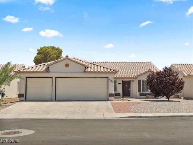 4323 Pageantry Falls Dr, North Las Vegas, NV 89031 - mediterranean / spanish-style home with an attached garage, concrete driveway, stucco siding, and a tiled roof