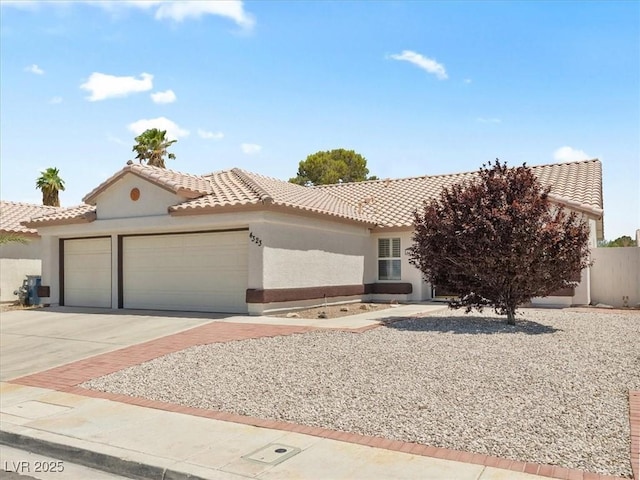 4323 Pageantry Falls Dr, North Las Vegas, NV 89031 - view of front of property with a garage, a tile roof, concrete driveway, and stucco siding