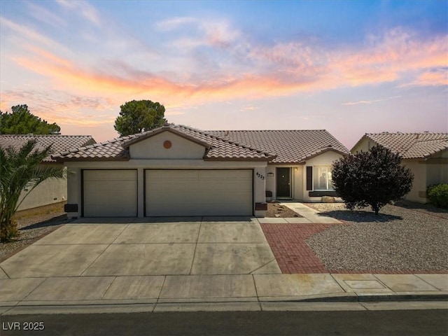 4323 Pageantry Falls Dr, North Las Vegas, NV 89031 - mediterranean / spanish home with a garage, concrete driveway, stucco siding, and a tile roof