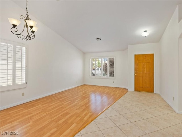 4323 Pageantry Falls Dr, North Las Vegas, NV 89031 - spare room featuring a chandelier, vaulted ceiling, and light wood-style flooring
