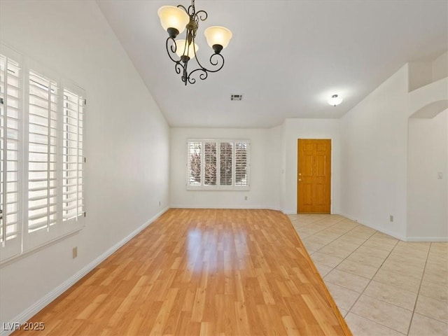 4323 Pageantry Falls Dr, North Las Vegas, NV 89031 - spare room with lofted ceiling, a chandelier, wood finished floors, and arched walkways