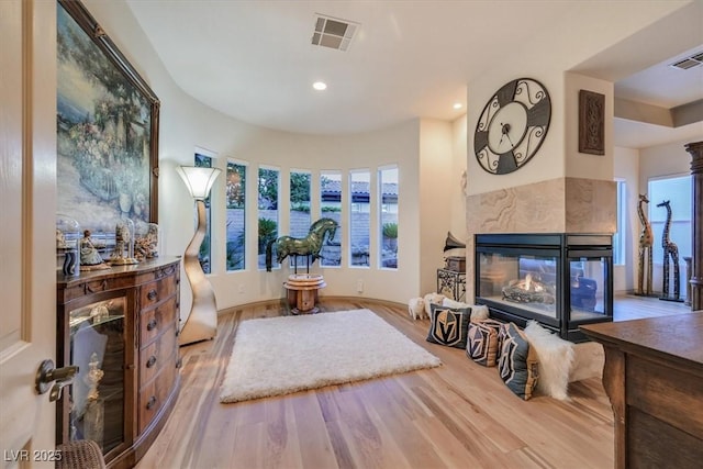 69 Tapadero Ln, Las Vegas, NV 89135 - living room featuring wood finished floors, plenty of natural light, a multi sided fireplace, and recessed lighting