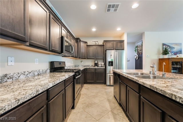 151 Duckhook Ave, Las Vegas, NV 89148 - kitchen with stainless steel appliances, dark brown cabinetry, light stone countertops, light tile patterned floors, and recessed lighting