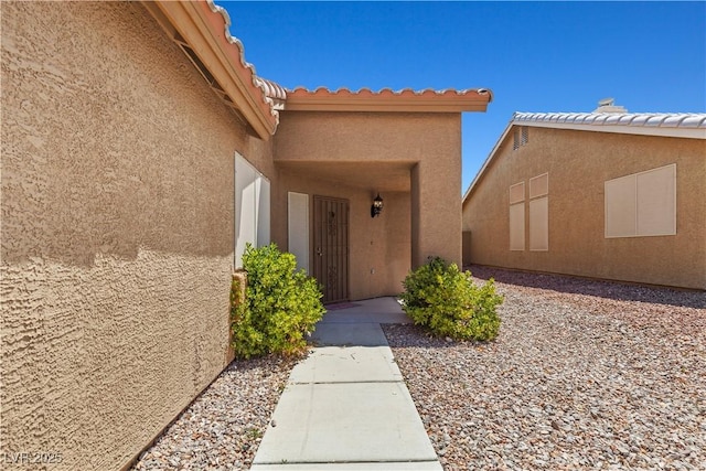 7825 White Grass Ave, Las Vegas, NV 89131 - doorway to property featuring stucco siding and a tiled roof