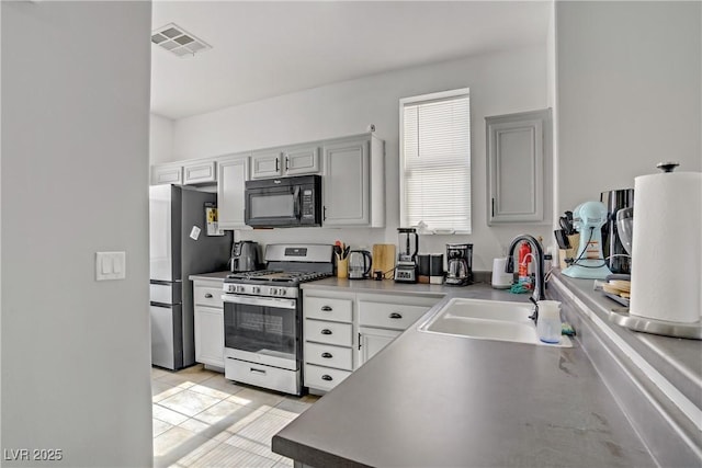 5324 Pendergrass St, North Las Vegas, NV 89081 - kitchen with stainless steel appliances, gray cabinetry, and light tile patterned flooring