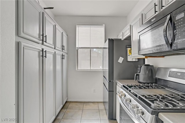 5324 Pendergrass St, North Las Vegas, NV 89081 - kitchen with stainless steel gas stove, black microwave, light tile patterned flooring, and light countertops