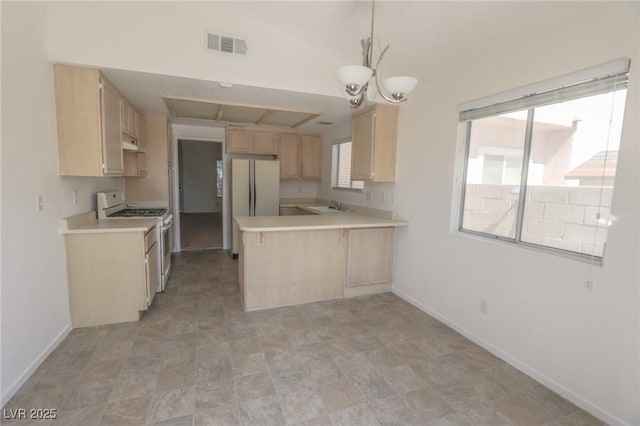 1349 Goldenglow Rd, Las Vegas, NV 89108 - kitchen featuring white appliances, light brown cabinets, light countertops, and a peninsula