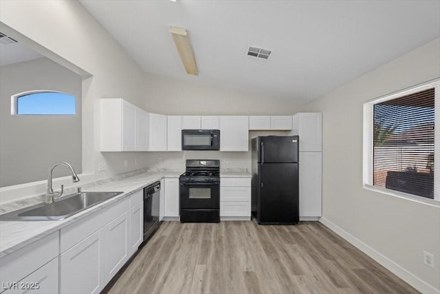 905 Harp Way N, Las Vegas, NV 89032 - kitchen with black appliances, white cabinets, light wood-type flooring, lofted ceiling, and light stone countertops