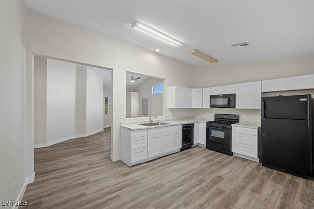 905 Harp Way N, Las Vegas, NV 89032 - kitchen featuring black appliances, lofted ceiling, white cabinetry, light countertops, and light wood-style flooring
