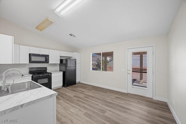 905 Harp Way N, Las Vegas, NV 89032 - kitchen with black appliances, light countertops, white cabinetry, light wood-style floors, and lofted ceiling