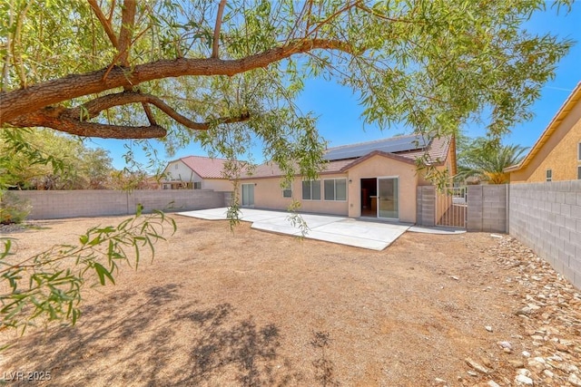 3604 Cantura Crest Ct, North Las Vegas, NV 89031 - back of house featuring solar panels, a fenced backyard, stucco siding, and a gate