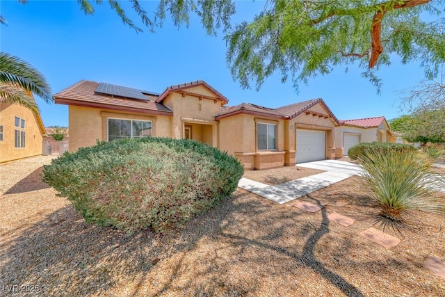 3604 Cantura Crest Ct, North Las Vegas, NV 89031 - mediterranean / spanish-style home featuring an attached garage, stucco siding, a tiled roof, roof mounted solar panels, and concrete driveway