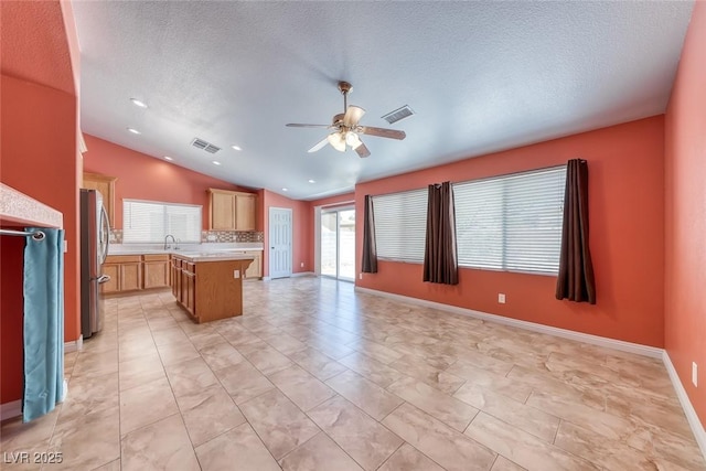 3604 Cantura Crest Ct, North Las Vegas, NV 89031 - kitchen with vaulted ceiling, light countertops, open floor plan, freestanding refrigerator, and ceiling fan