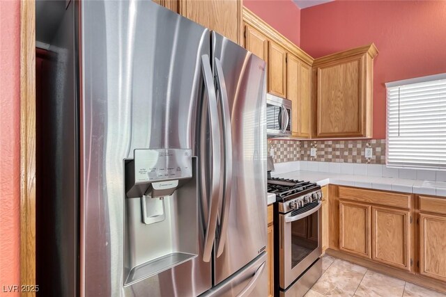 3604 Cantura Crest Ct, North Las Vegas, NV 89031 - kitchen with stainless steel appliances, backsplash, light tile patterned floors, and tile counters