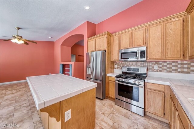 3604 Cantura Crest Ct, North Las Vegas, NV 89031 - kitchen with appliances with stainless steel finishes, tile counters, arched walkways, a ceiling fan, and recessed lighting