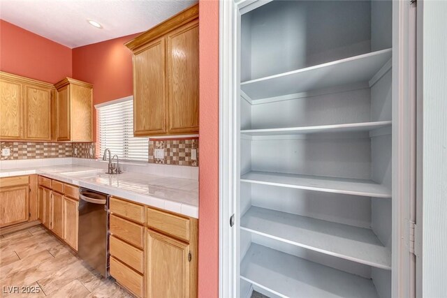 3604 Cantura Crest Ct, North Las Vegas, NV 89031 - kitchen with stainless steel dishwasher, backsplash, and tile countertops