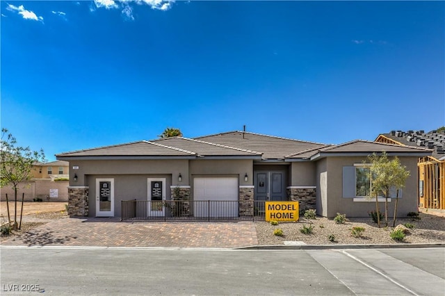 365 Sapphire Rock Ave, Las Vegas, NV 89183 - view of front of house featuring stone siding, a garage, stucco siding, driveway, and a tiled roof